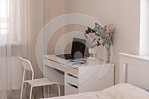 White desktop with laptop for remote work or study. Office computer workplace in home interior