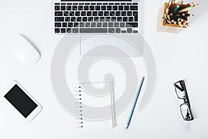 White desktop with smartphone and notepad