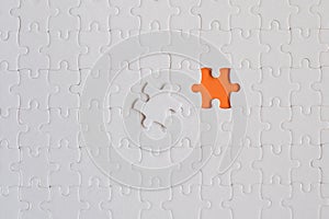 White details of jigsaw puzzle on orange background