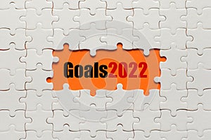 White details of puzzle on orange background and word Goals 2022