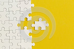 White details of puzzle on yellow background. Business strategy, teamwork