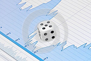 White dice on digital screen with financial chart