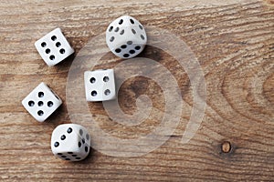 White dice on wooden table from above. Gambling devices. Game of chance concept.