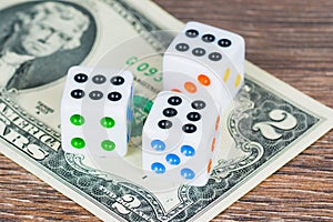 White dices with colorful dots and two dollars banknote