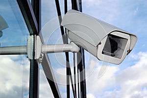 White Digital CCTV camera on the glass facade