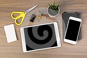 White digital tablet and mobile phone on an office working dark wooden table