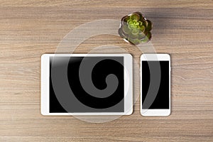 White digital tablet and mobile phone on an office working dark wooden table