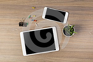 White digital tablet and mobile phone on an office working dark wooden table