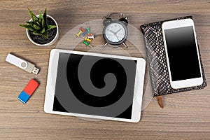 White digital tablet and mobile phone on an office working dark wooden table