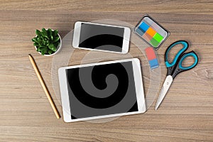 White digital tablet and mobile phone on an office working dark wooden table