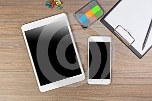 White digital tablet and mobile phone on an office working dark wooden table