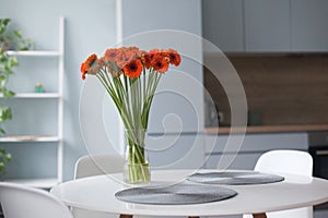 White dinning table in front of scandinavian kitchen, elegant nordic design and interior decor