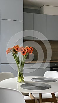 White dinning table in front of scandinavian kitchen, elegant nordic design and interior decor