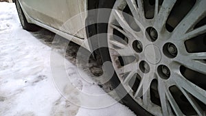 White Dirty Car wheel on road. Messy, Mud, salt, chemicals in winter. Tire. Ecology problem in city. Protection and wash vehicle