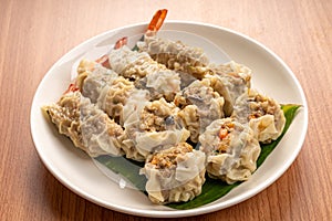 White Dish of Asian Steam  Dumplings  or Dim Sum a Famous Chinese Food  with Pork and Shrimp on  Wood Table