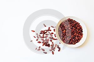White dish and scattered piquin bird peppers Capsicum annuum Pequin pepper, food ingredient, dried red, isolated on