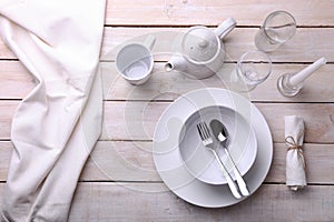 White dishes, cutlery, glasses and candles