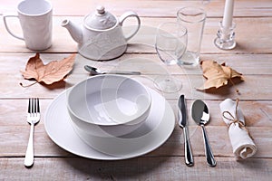 White dishes, cutlery, glasses and candles