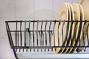 White dishes drying on a metal dish rack. Drying rack for dishes