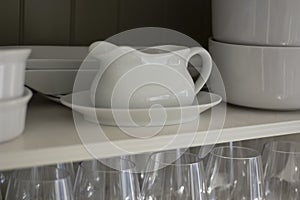 White Dishes and Glasses in a White Cupboard
