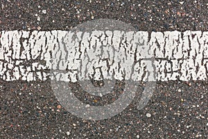 White dividing line with cracks over dark gray asphalt