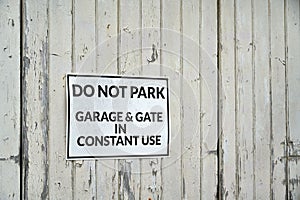 White do not park warning sign on white weathered wooden garage door