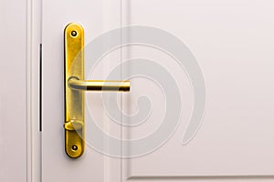 White door and golden handle. Entrance to a house, apartment, office or bedroom. Detail of the interior