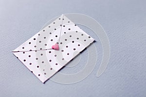 White dotted envelope with pink heart shaped figure. Hand crafted love letter for Saint Valentines Day celebration