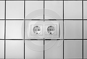 White double electrical outlet mounted on white wall