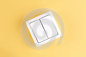 White double light switch isolated on yellow background