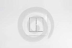 White double light switch mounted on a white wall
