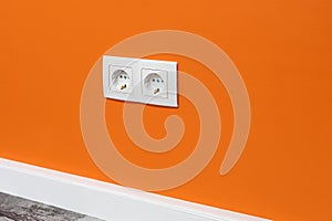 White double outlet on orange wall