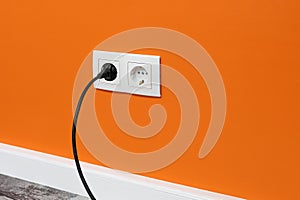 White double outlet on orange wall