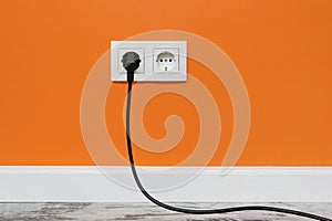 White double outlet on orange wall