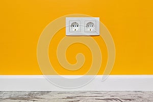 White double outlet on yellow wall