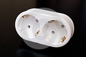 White double socket on black wooden table