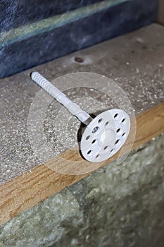 White dowel for insulation. The holder of mineral wool slabs when warming a frame wooden house.