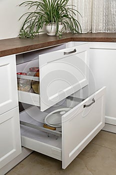 White drawers in kitchen set. Open furniture drawers