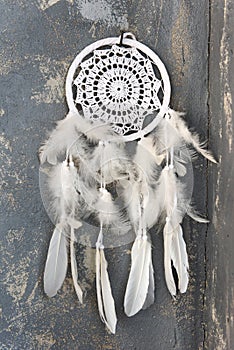 White dreamcatcher close up on dark gray textured background