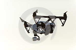 White drone with digital camera flying on sky background