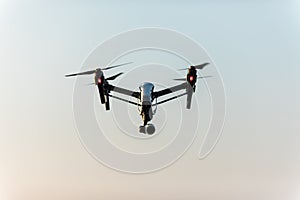 White drone with digital camera flying on sky background