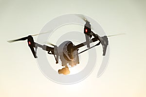 White drone with digital camera flying on sky background