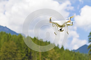 White drone flying above mountains.