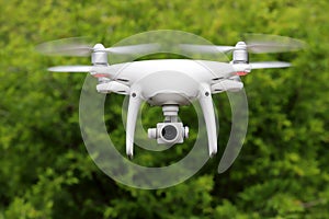 White drone flying in the forest