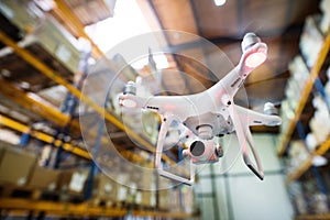 White drone flying inside the warehouse.