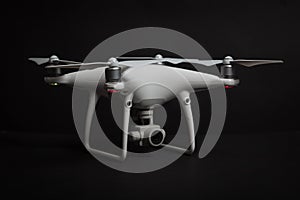 White drone Quadrocopter with camera on gimbal on dark background