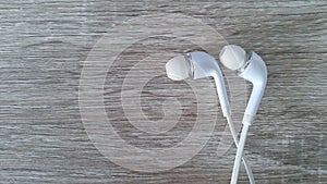 White earphone on wooden background