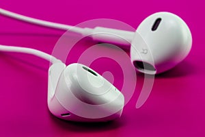 White earphone on pink background