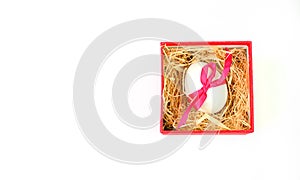 White easter egg tied with a red ribbon lies in a red gift box isolated on a white background.