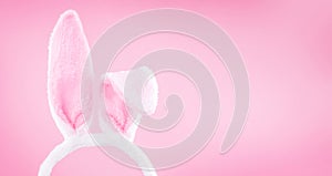 White easter rabbit ears on a light pink background with copy space